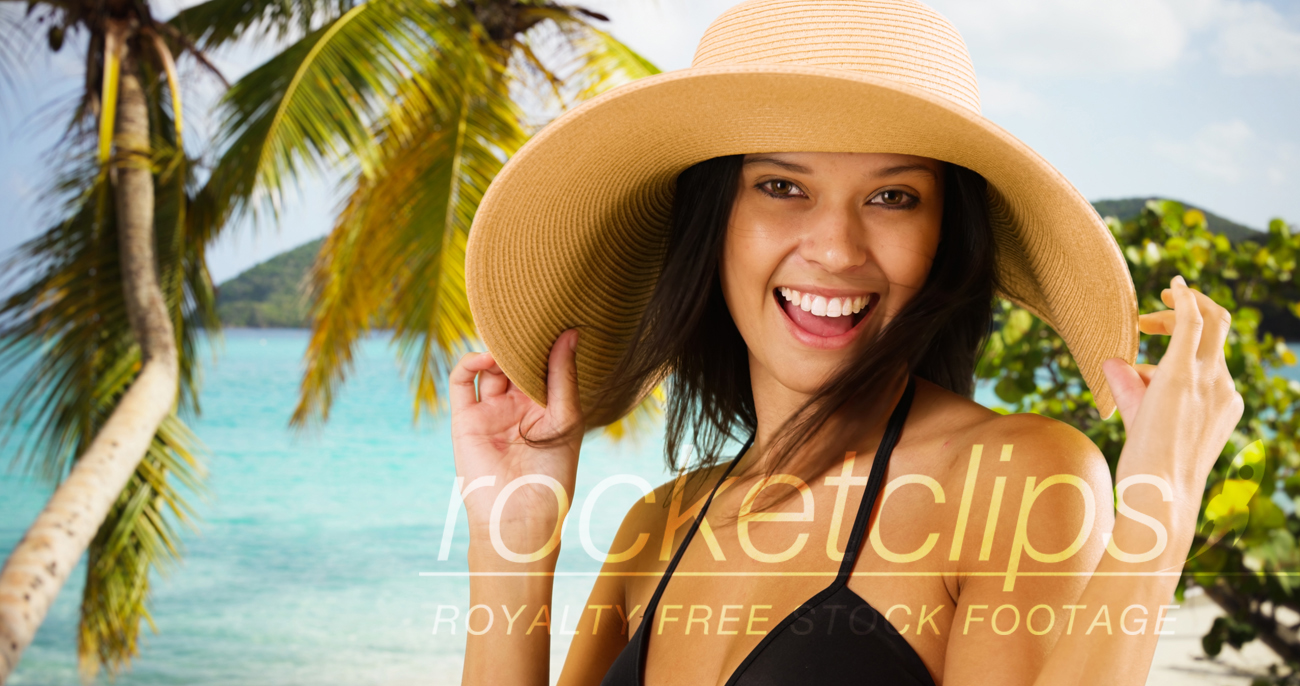 Young white girl in a sun hat poses for a portrait on a Caribbean beach