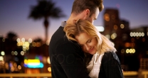 Sweet modern couple hugging outdoors at night