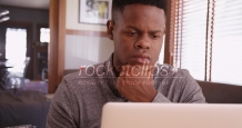 Black guy working on his laptop