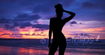 Single silhouette of sensual woman standing on sunset beach in Hawaii