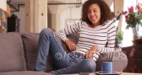 Millennial black woman lounges in her modern apartment