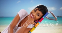 Young black female sitting by the ocean on Caribbean beach talking to camera
