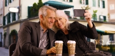 Sweet elderly couple taking selfies outdoors