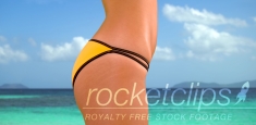 Side view of a millennial white girl in a yellow bikini