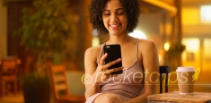 Attractive black woman watching cute cat videos on her smartphone device