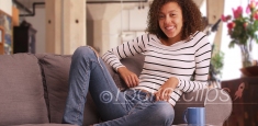 Millennial black woman lounges in her modern apartment