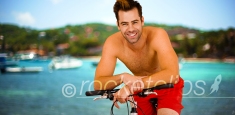 Young hot millennial sitting on bike smiling at camera