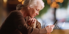 Side portrait of old woman reading concerning text on smartphone at cafe