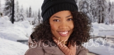 Kind black millennial girl smiling at camera outdoors in snowy setting